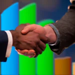 Two business professionals shaking hands with a chart showing positive growth in the background.